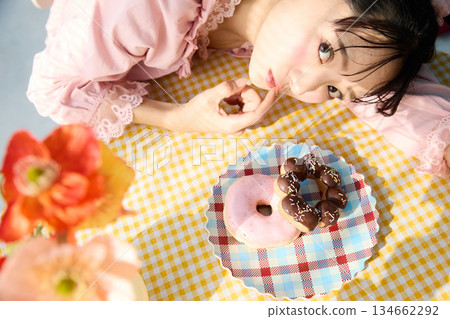 Portrait of a cute woman eating a donut in a colorful room 134662292