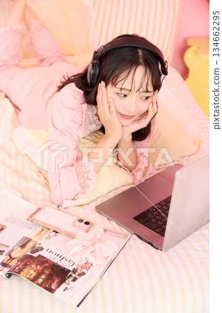 一位年輕的亞洲女性身穿睡衣，在溫馨的房間裡放鬆休息的肖像 134662295