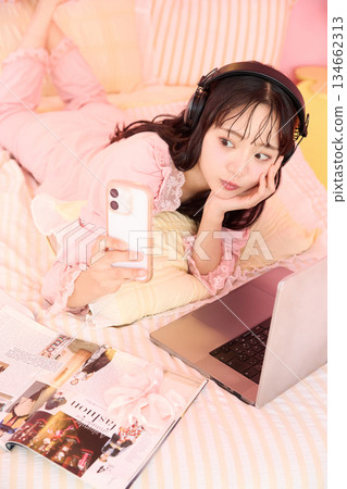 Portrait of a young Asian woman relaxing in pajamas in a cute room Portrait of a young Asian woman relaxing in pajamas in a cute room 134662313