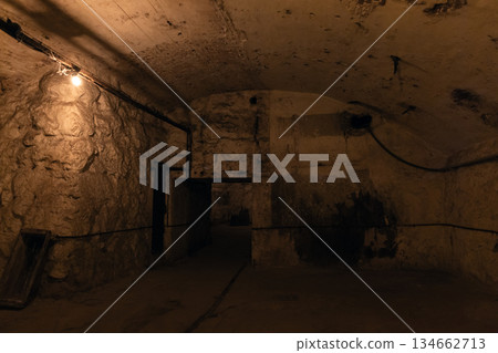 A dim underground basement scene with rough stone walls A dim underground basement scene with rough stone walls 134662713