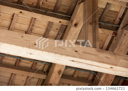 A close view of heavy timber beams and roof framing in a building under construction A close view of heavy timber beams and roof framing in a building under construction 134662721