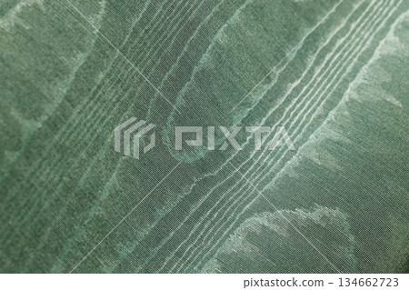 Rich, detailed close-up of green fabric showing fine weave, diagonal stripes 134662723
