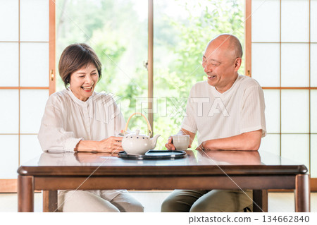 一對老年夫婦在日式房間喝茶，窗外是鬱鬱蔥蔥的綠植。 134662840