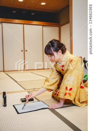一位身著和服的年輕女子正在日式房間練習書法。 134662868
