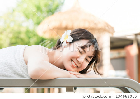 A woman receiving a massage at a tropical spa, beauty salon, or esthetic salon 134663019