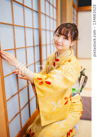 A young woman in a kimono trying to open a shoji screen 134663028