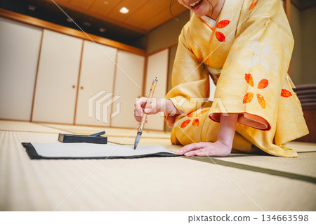 Hands practicing calligraphy in a kimono 134663598
