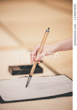 Hands practicing calligraphy in a kimono 134663605
