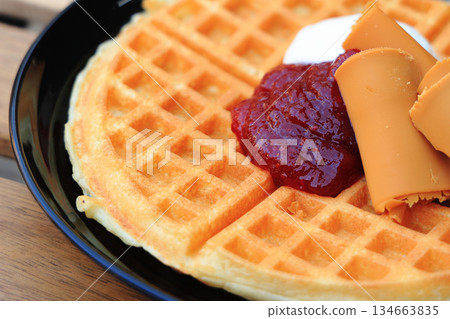 Delicious thin Nordic waffles served with strawberry jam, cream and brown cheese Delicious thin Nordic waffles served with strawberry jam, cream and brown cheese 134663835