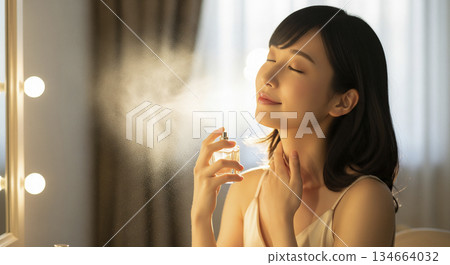 Woman spraying perfume 134664032