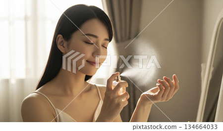 Woman spraying perfume 134664033