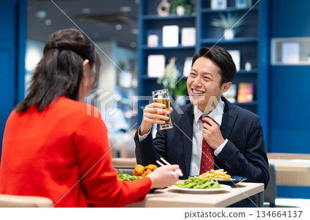 一位中年商人與一位女士一起喝啤酒。 134664137