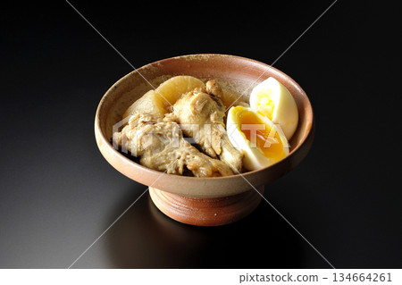 雞翅、蘿蔔和雞蛋用甜辣醬燉煮，在黑色背景下拍攝。 134664261