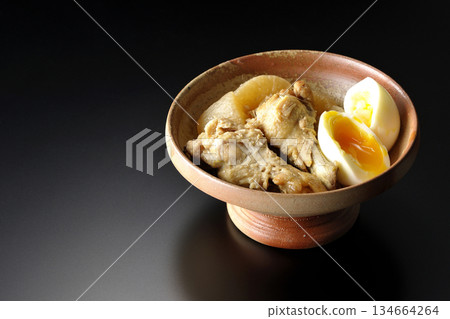 Chicken wings, radish, and egg stewed in sweet and spicy sauce photographed against a black background Chicken wings, radish, and egg stewed in sweet and spicy sauce photographed against a black background 134664264