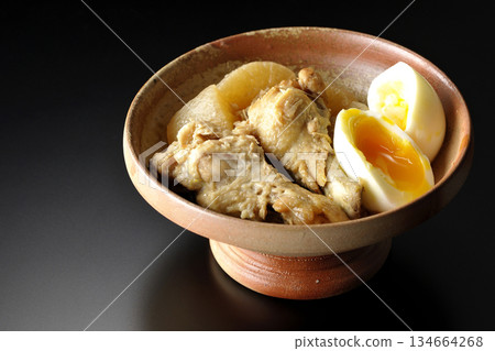 雞翅、蘿蔔和雞蛋用甜辣醬燉煮，在黑色背景下拍攝。 134664268