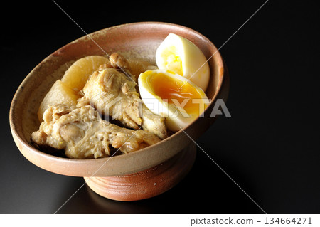 雞翅、蘿蔔和雞蛋用甜辣醬燉煮，在黑色背景下拍攝。 134664271