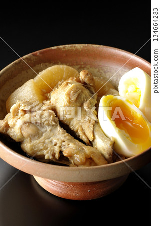 雞翅、蘿蔔和雞蛋用甜辣醬燉煮，在黑色背景下拍攝。 134664283