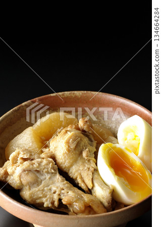 Chicken wings, radish, and egg stewed in sweet and spicy sauce photographed against a black background Chicken wings, radish, and egg stewed in sweet and spicy sauce photographed against a black background 134664284