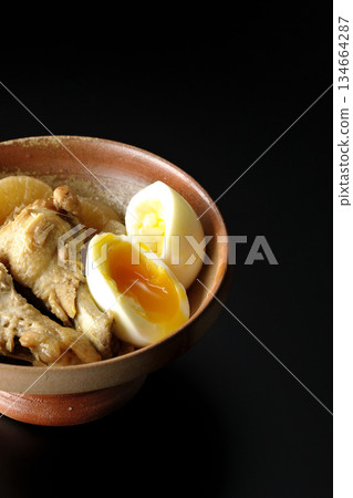 雞翅、蘿蔔和雞蛋用甜辣醬燉煮，在黑色背景下拍攝。 134664287