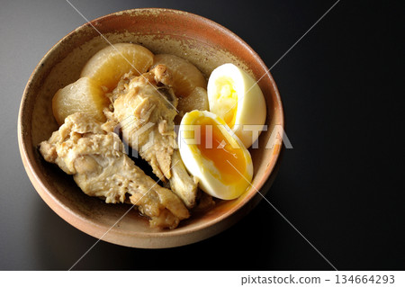雞翅、蘿蔔和雞蛋用甜辣醬燉煮,在黑色背景下拍攝。 雞翅、蘿蔔和雞蛋用甜辣醬燉煮,在黑色背景下拍攝。 134664293