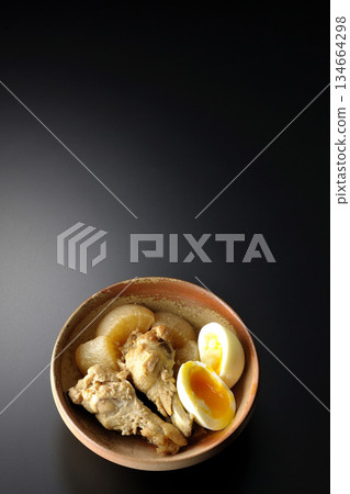 雞翅、蘿蔔和雞蛋用甜辣醬燉煮,在黑色背景下拍攝。 雞翅、蘿蔔和雞蛋用甜辣醬燉煮,在黑色背景下拍攝。 134664298