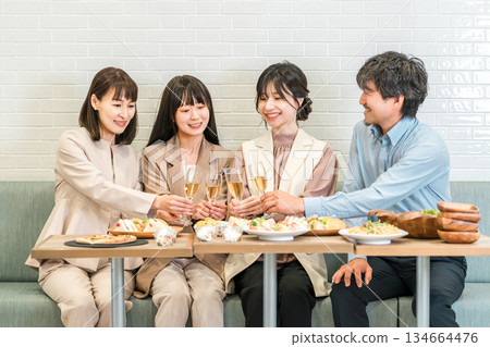 Businessmen and businesswomen having a dinner or drinking party at a restaurant Businessmen and businesswomen having a dinner or drinking party at a restaurant 134664476