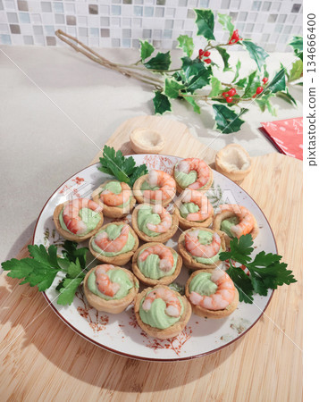 Cold appetizer for holiday table. Shortcrust pastry baskets with shrimp and cream cheese and spinach filling. Homemade healthy seafood. 134666400