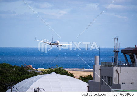 A passenger plane landing at Hachijojima Airport. A view of the remote island airport with the sea in the background. A passenger plane landing at Hachijojima Airport. A view of the remote island airport with the sea in the background. 134666900