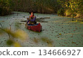 Cowboy in a canoe floats on the river 134666927