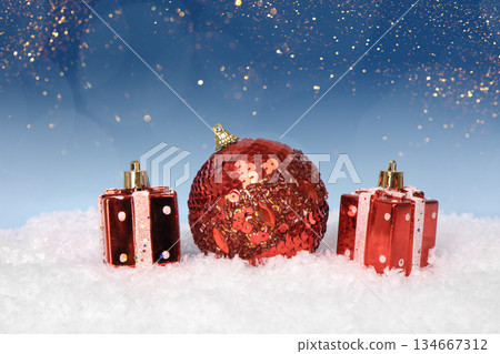 Christmas tree baubles on blue background with white snow and golden lights. Festive winter holiday background. Design with copy space for greeting card, text, advertising, banner, invitation Christmas tree baubles on blue background with white snow and golden lights. Festive winter holiday background. Design with copy space for greeting card, text, advertising, banner, invitation 134667312