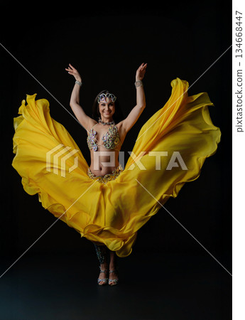 Woman performs dance with snake in colorful outfit during evening show 134668447