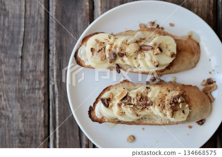 Banana and mixed nuts tartine, baguette open sandwich Banana and mixed nuts tartine, baguette open sandwich 134668575