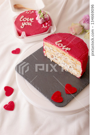 Romantic cake with red frosting and heart decorations on slate plate Romantic cake with red frosting and heart decorations on slate plate 134669096