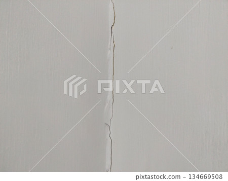 structural crack running down smooth white wall 134669508