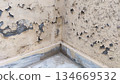 damaged wall corner with exposed concrete base 134669532