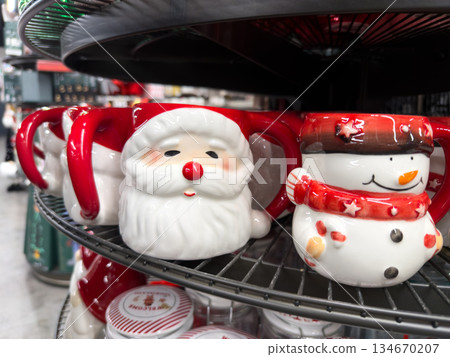 Festive ceramic Santa Claus and snowman mugs displayed on a retail shelf, embodying the joyful spirit of Christmas and winter holiday gifting Festive ceramic Santa Claus and snowman mugs displayed on a retail shelf, embodying the joyful spirit of Christmas and winter holiday gifting 134670207