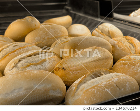 A bakery display features numerous fresh, golden-brown bread rolls with rustic flour dusting, ideal for breakfast, lunch, or daily meals A bakery display features numerous fresh, golden-brown bread rolls with rustic flour dusting, ideal for breakfast, lunch, or daily meals 134670214