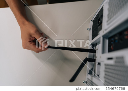 Top view of male hand installing network antenna into desktop computer, establishing wireless internet connection for device and enabling high-speed data transfer. Top view of male hand installing network antenna into desktop computer, establishing wireless internet connection for device and enabling high-speed data transfer. 134670766