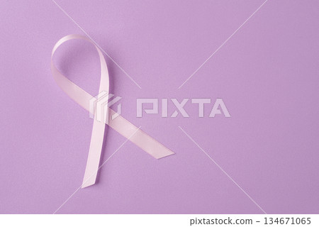 Lilac ribbon on purple background. 134671065