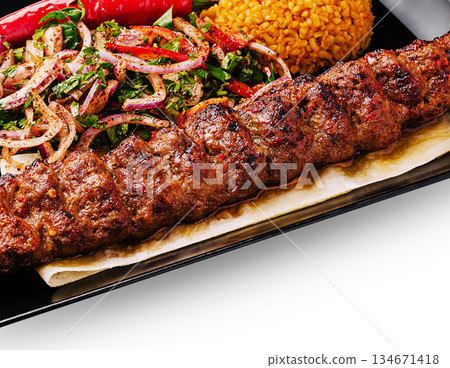 Delicious kebab served with rice and fresh salad at a local restaurant 134671418
