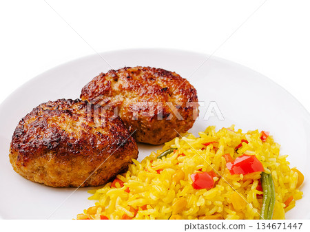 Delicious meat patties served with vibrant yellow rice and vegetables Delicious meat patties served with vibrant yellow rice and vegetables 134671447