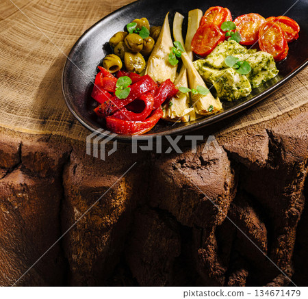 Colorful vegetable platter served on a rustic wooden table in natural setting 134671479