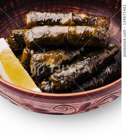 Delicious homemade stuffed grape leaves served in a traditional bowl Delicious homemade stuffed grape leaves served in a traditional bowl 134671481