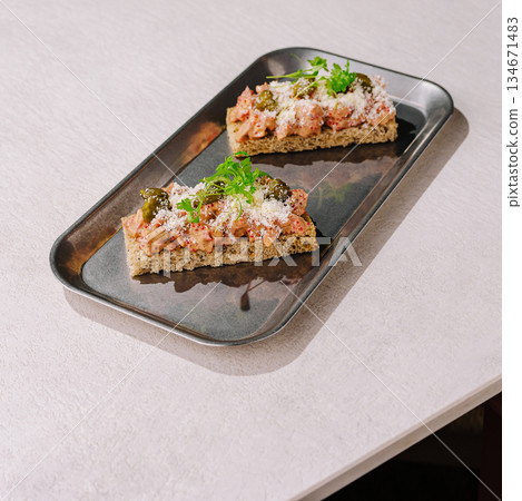 Delicious open-faced sandwich on a metal platter at a cozy cafe setting Delicious open-faced sandwich on a metal platter at a cozy cafe setting 134671483