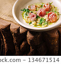 Delicious dish featuring prosciutto and greens served in a rustic bowl 134671514