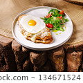 Delicious breakfast plate with egg and salad on rustic wooden table 134671524
