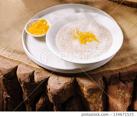 Creamy porridge topped with coconut flakes 134671525
