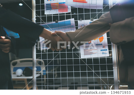 Business people shaking hands in office. Two business partners shaking hands after signing a contract in office. 134671933