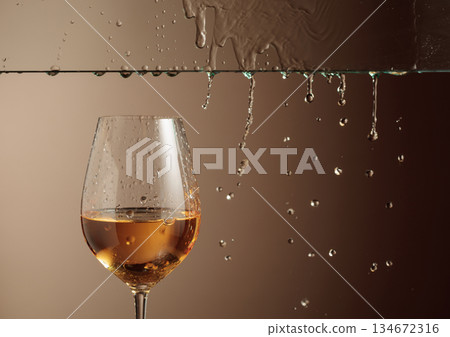 White wine flows down into a glass. 134672316