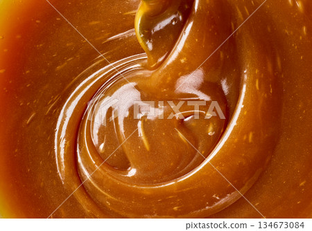 freshly cooked caramel sauce background freshly cooked caramel sauce background 134673084